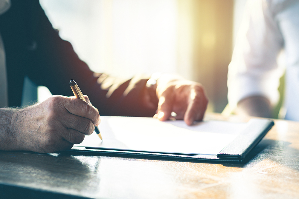 male-in-business-attire-signing-document