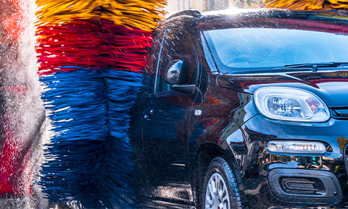 Passenger side of car being washed with colorful carwash side brushes